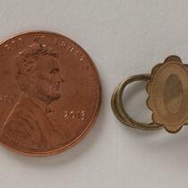 Physical object: Cufflink belonging to Charles S. Stratton (with penny for scale)
